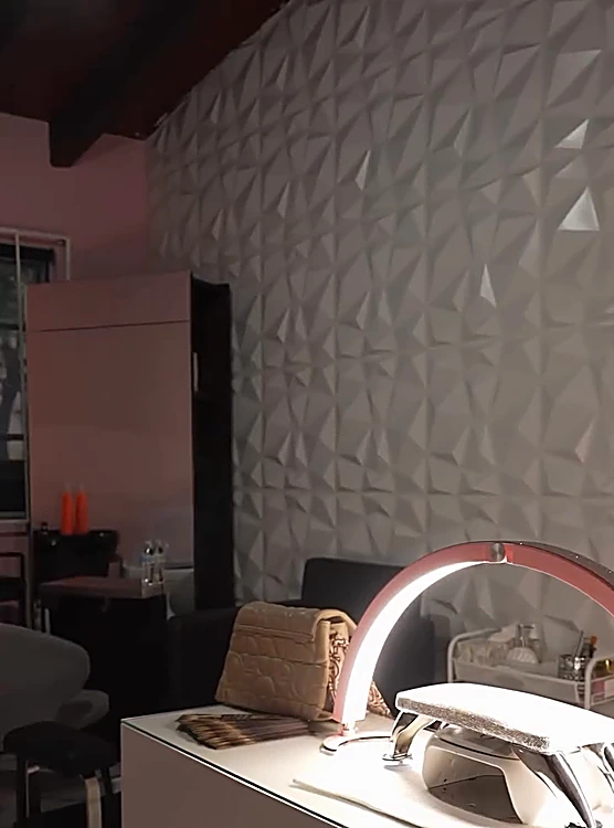 Sala de uñas e imagen con muro texturizado blanco y lámpara de secado